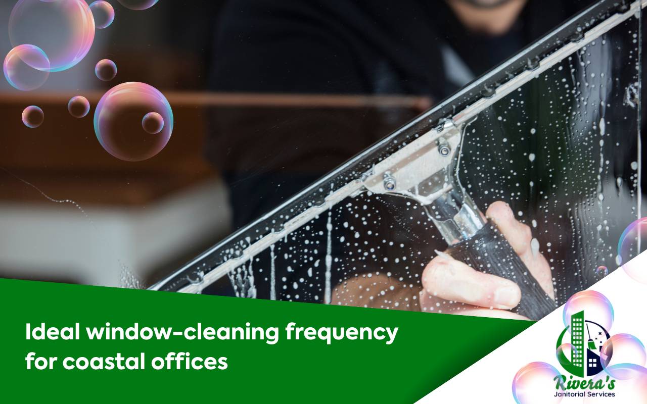 Technician performing exterior cleaning on a low-rise coastal office window following a professional maintenance schedule